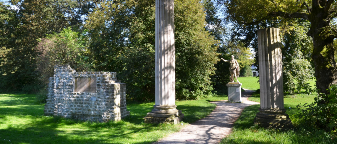 Blick durch zwei antike Säulen auf Augustus-Statue im Archäologischen Park Cambodunum